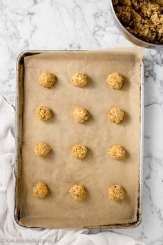 doughnut holes are lined up on a baking sheet