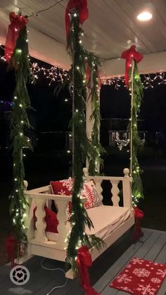 a porch swing decorated for christmas with lights on the ceiling and garlands around it