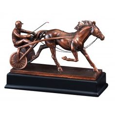 a bronze statue of a man on a horse pulling a cart with a person in it