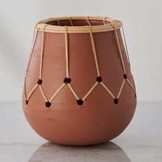 a brown vase sitting on top of a white table next to a wall and floor