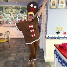 a woman in a costume is posing with her arms up while wearing a large cookie hat