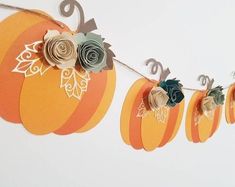 paper pumpkins are hanging on a string