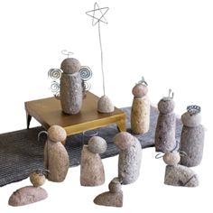 a group of rocks sitting on top of a wooden table next to a wire sculpture