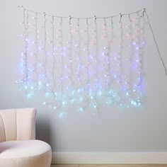 a white chair sitting next to a wall covered in lights