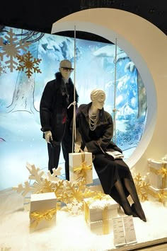 two mannequins dressed in black and white are sitting on the window display