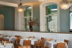 an empty restaurant with tables and chairs set up for formal dining in front of large windows