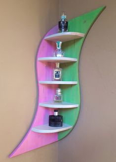 a shelf that has some bottles on it and is painted pink, green and blue