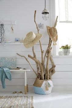 a white room with some hats on top of the branches and a rug in front of it