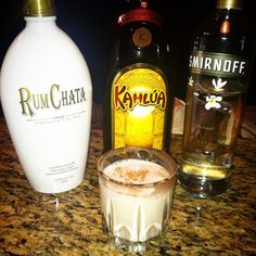 an alcoholic drink next to two bottles of rumchata on a counter top,