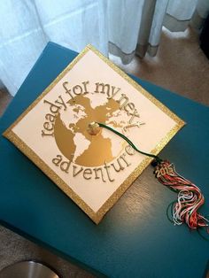 a graduation cap that says ready for my next adventure on top of a blue table