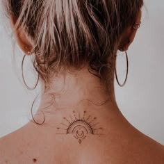 a woman with a sun tattoo on her back neck