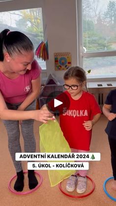 a woman teaching two children how to fly kites in a room filled with toys