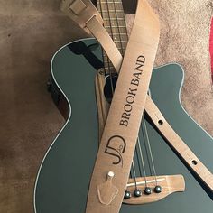 a guitar strap with the name and number engraved on it sitting next to an electric guitar