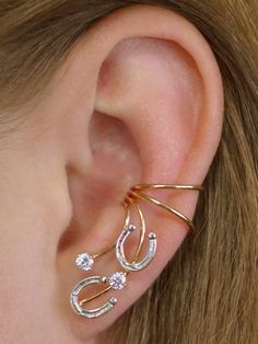 What is not to love about this gorgeous Horseshoe non*pierced ear cuff! The horseshoes are delicate but very detailed, and accented by two cubic zirconia to add a little variation and pizzazz . It fits gracefully up the natural shape of your ear with shimmer and pizzazz! This earring requires no piercing and sit securely in the center of your ear. We use only the highest quality materials Sterling Silver and 14K Gold Filled. This piece will arrive in a Gift Box and include simple fitting instruc Ear Cuff Gold, Horse Ears, Ear Crawler, Country Jewelry, Ear Crawlers, Pierced Ear, Ear Climber, Gold Ear Cuff, Wrap Earrings