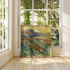 a painting is sitting on the floor in front of an open window with sunlight streaming through it