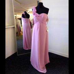 a pink dress is on display in front of a mirror and mannequins