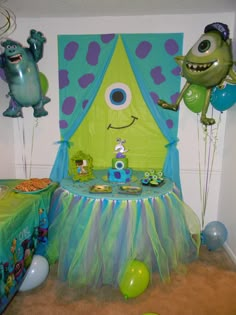 a birthday party with decorations and balloons in the shape of monsters, including one monster