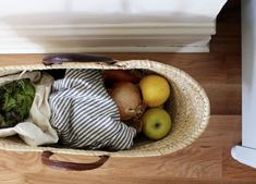 a basket filled with fruits and vegetables on top of a wooden floor