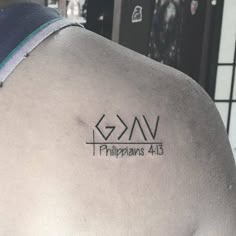 the back of a man's shoulder with a cross and name tattoo on it