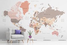 a living room with a couch, chair and large world map wall mural on the wall