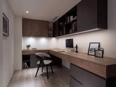 a home office with wooden flooring and black cabinetry, along with a white chair