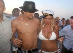 a man and woman in bikinis standing next to each other at a beach party