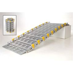 a metal conveyor belt with yellow wheels on the top and bottom, in front of a white background