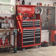 a red tool cabinet with tools on it in a room filled with workbenches