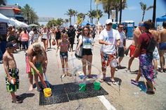 a group of people standing around with buckets and sand on the ground in front of them