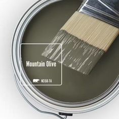 a paint can with a brush in it and the words mountain olive painted on it