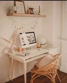 a white desk topped with a laptop computer next to a wooden chair and shelf filled with pictures