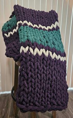 a crocheted blanket sitting on top of a wooden chair