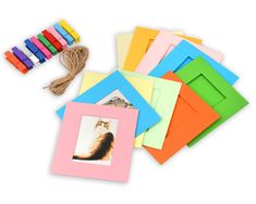 assorted colored cards with string and photo on white background, including one cat in the middle