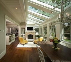 an image of a living room with skylights above the couches and dining table