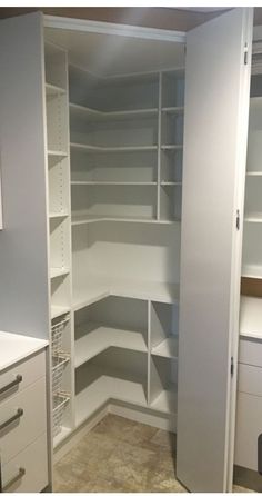 an empty closet with white shelves and drawers