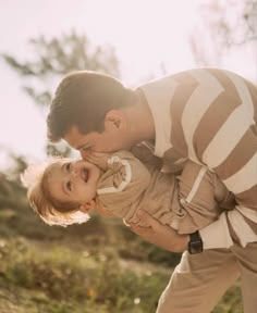 a man is holding a small child in his arms