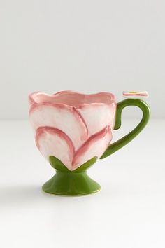 a pink and white flower shaped vase sitting on top of a table