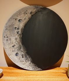 the moon is made out of concrete and has holes in it's side, along with a potted plant