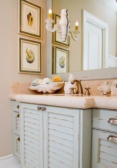 a bathroom with two sinks and pictures on the wall