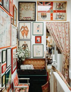 a room filled with lots of framed pictures on the wall