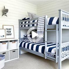 a bunk bed with blue and white striped bedspread in a child's room