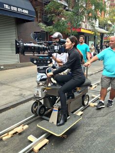 a woman sitting on top of a motorized scooter in the middle of a street