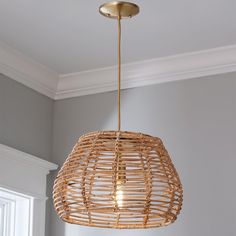 a rattan light fixture hanging from a ceiling in a room with gray walls and white trim