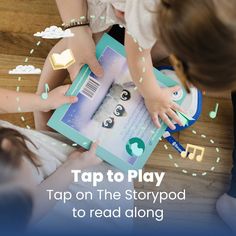 two children playing with an open book on the floor