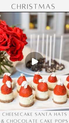 cheesecake santa hats and chocolate cake pops on a white platter with red roses in the background