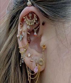 a close up of a person's ear with different types of jewelry on it