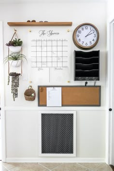 a wall with a clock, calendar and other items hanging on it's side