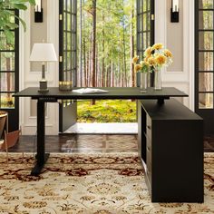 a room with a desk, chair and large window in front of the door that leads to another room