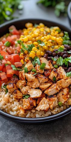 a black bowl filled with rice, chicken and veggies on top of a table