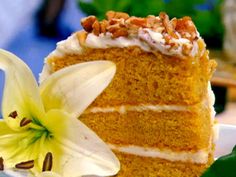 a piece of carrot cake with white frosting and flowers